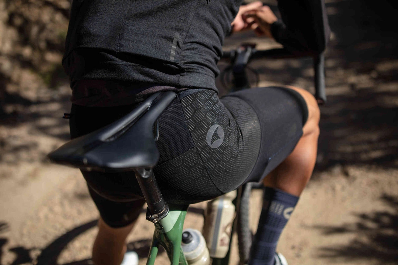 Close-up of a cyclist on a gravel bike wearing black cycling shorts with a patterned design.