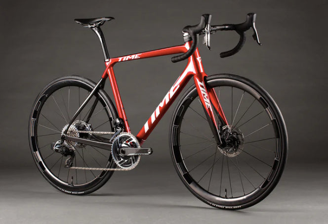 Red road bike with aerodynamic frame and drop handlebars.