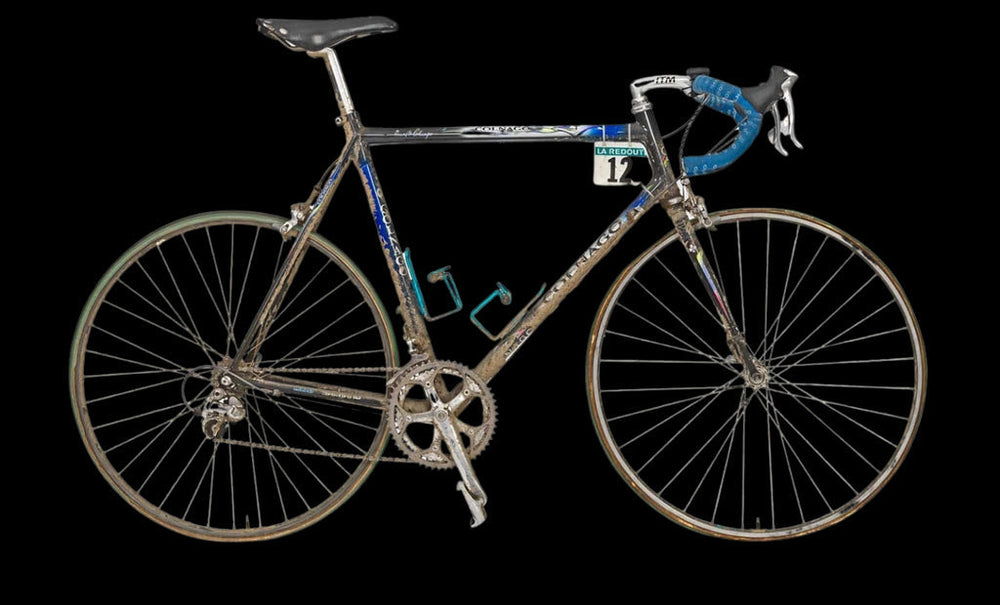 A vintage road bicycle with a blue patterned frame and drop handlebars.